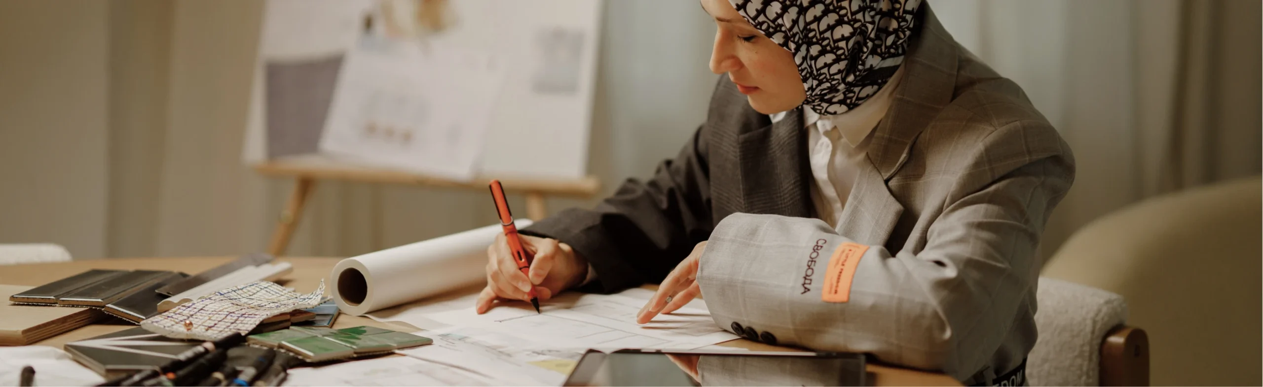 E Plus Interiors founder, Emine, working on her sketches on a table.